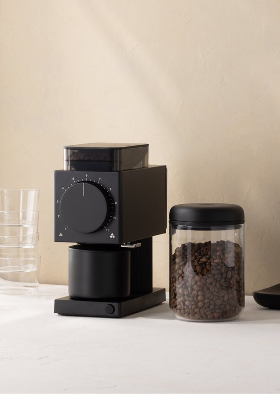 Ode grinder beside a coffee canister